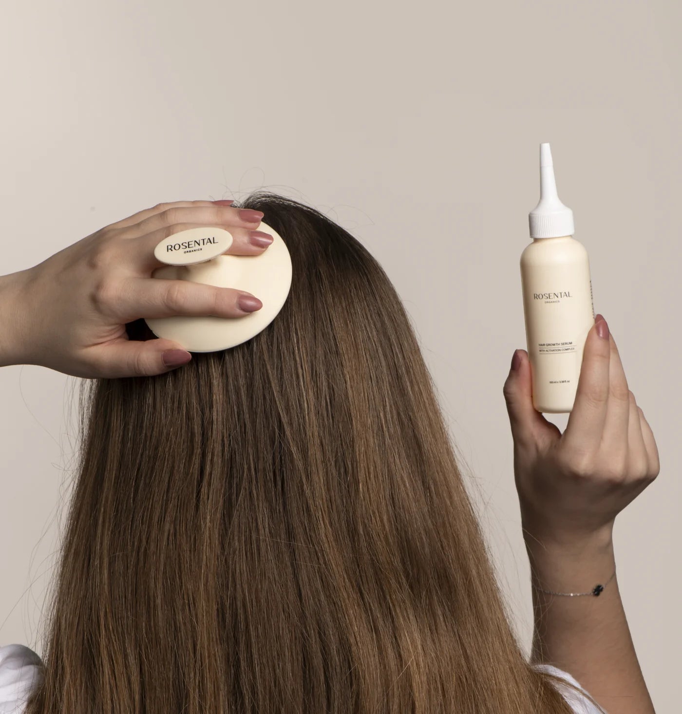 Person bürstet Haare mit Rosental-Bürste und hält Rosental-Produktflasche, neutraler Hintergrund.